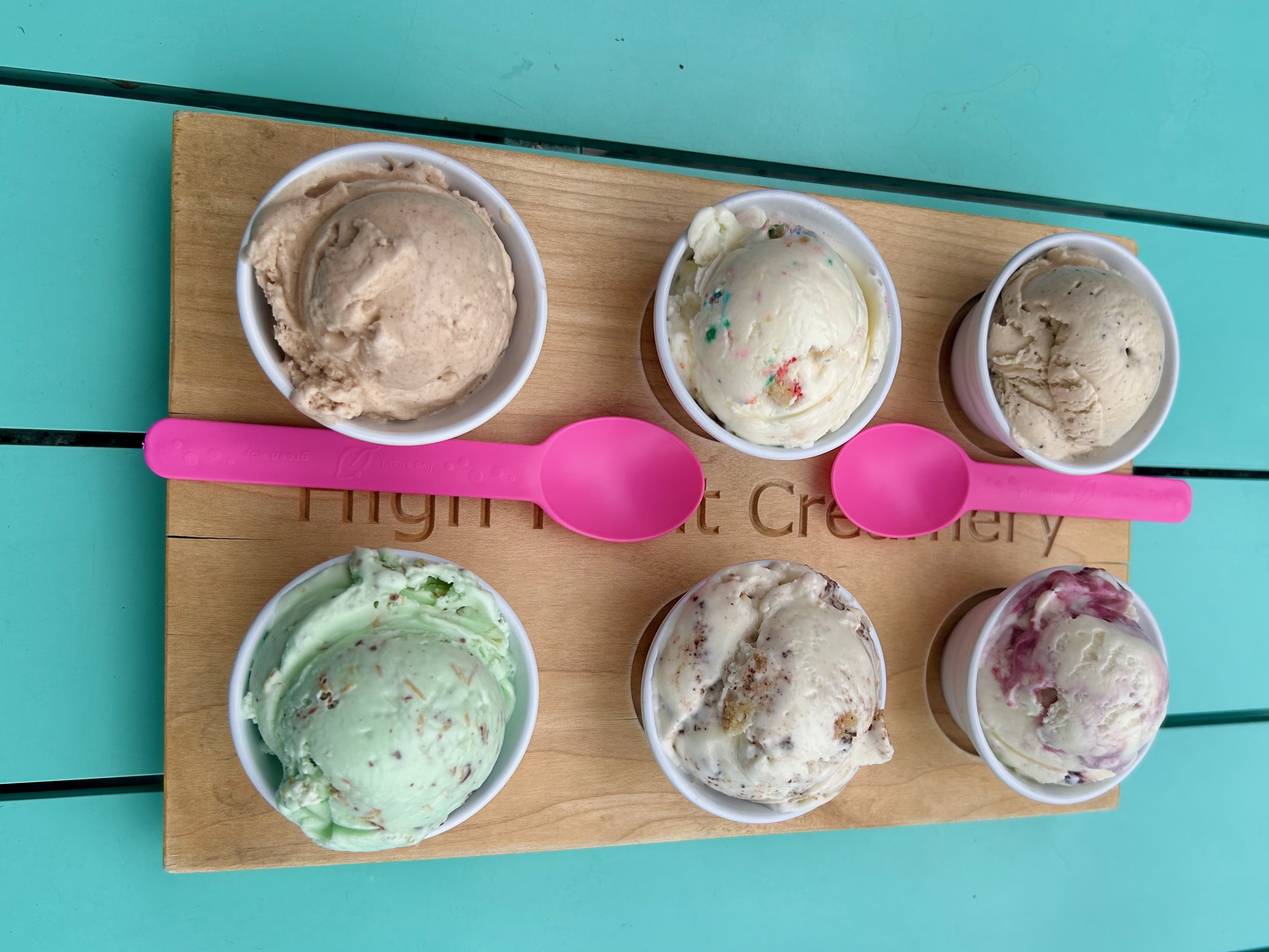 Six ice cream cups with two pink spoons