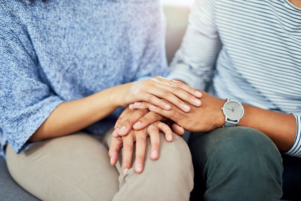 Couple in therapy holding hands in support