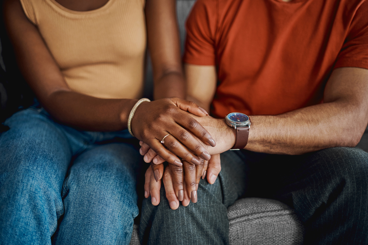Couple in therapy holding hands in support