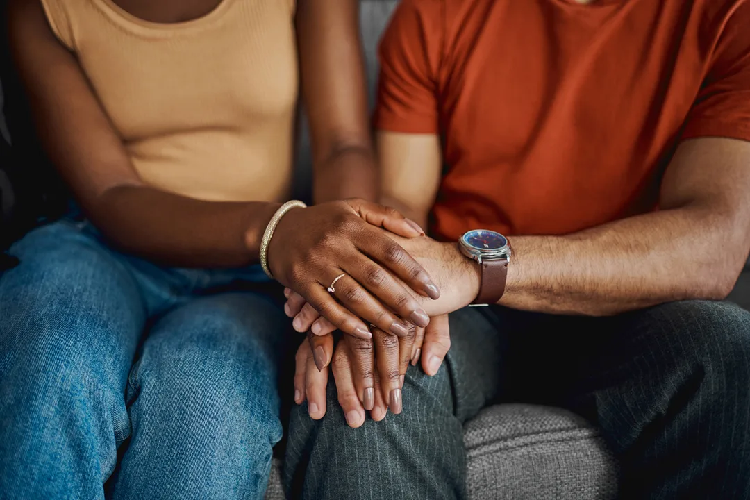 Couple in therapy holding hands in support
